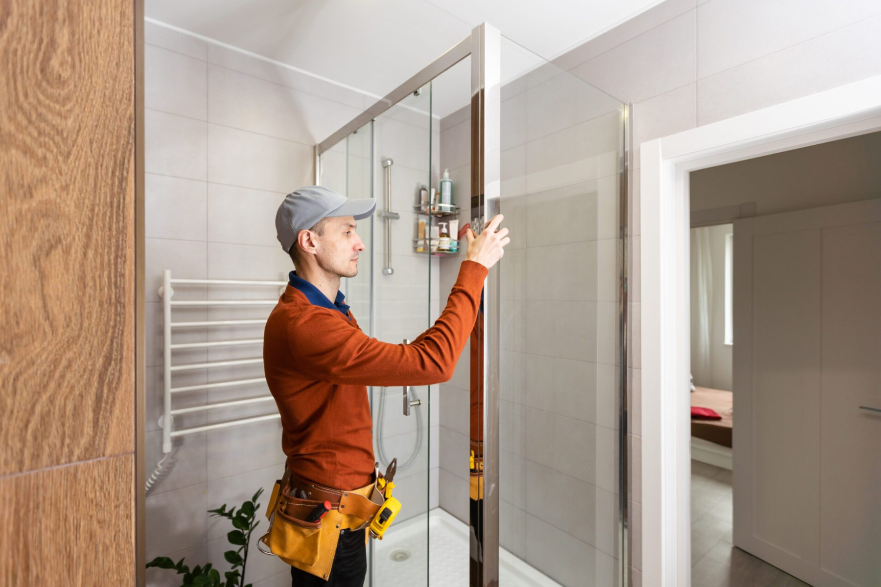 Man Installing Shower Enclosure In Modern Bathroom Space