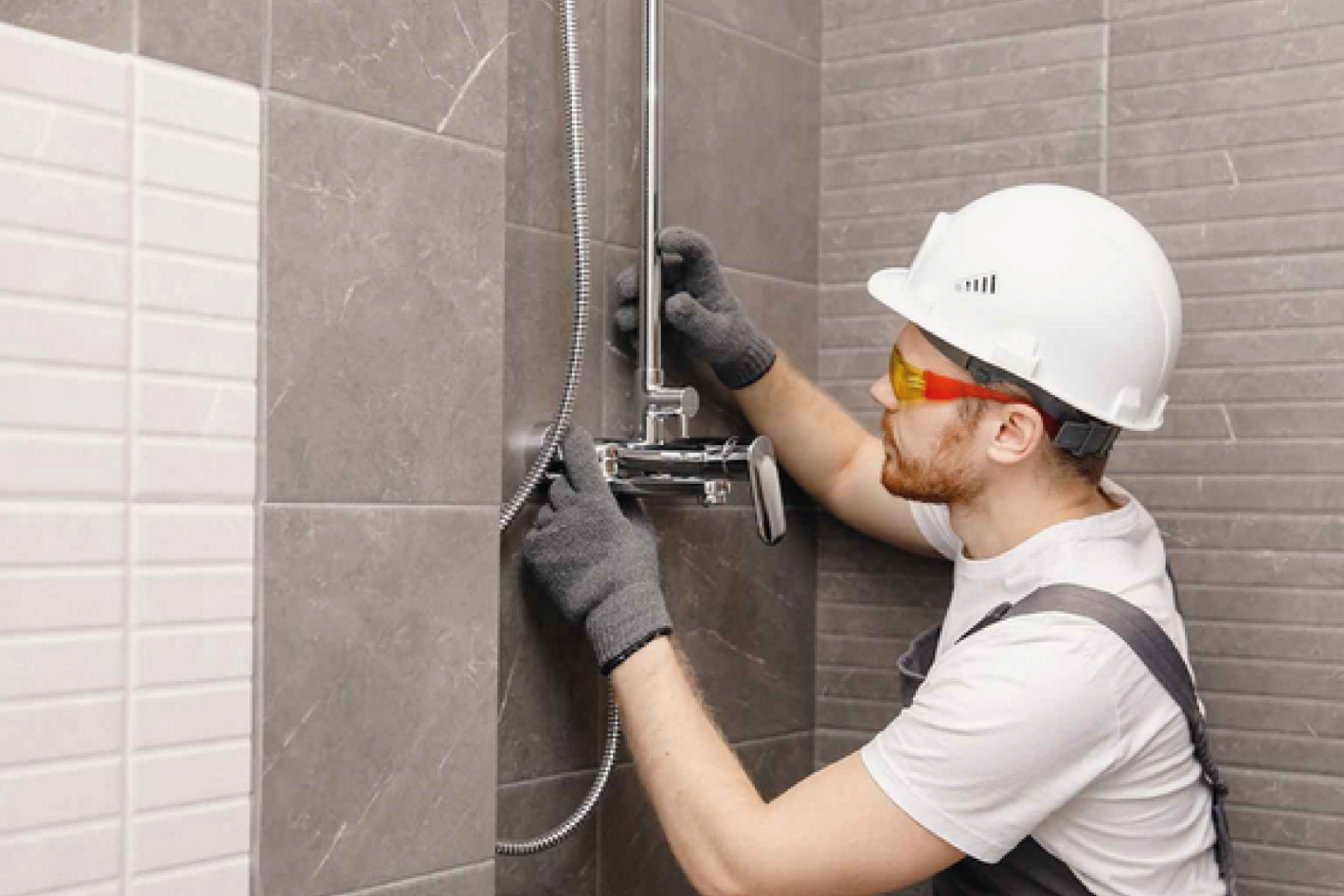 Plumber Installing Mixer Shower Mounted On Grey Wall