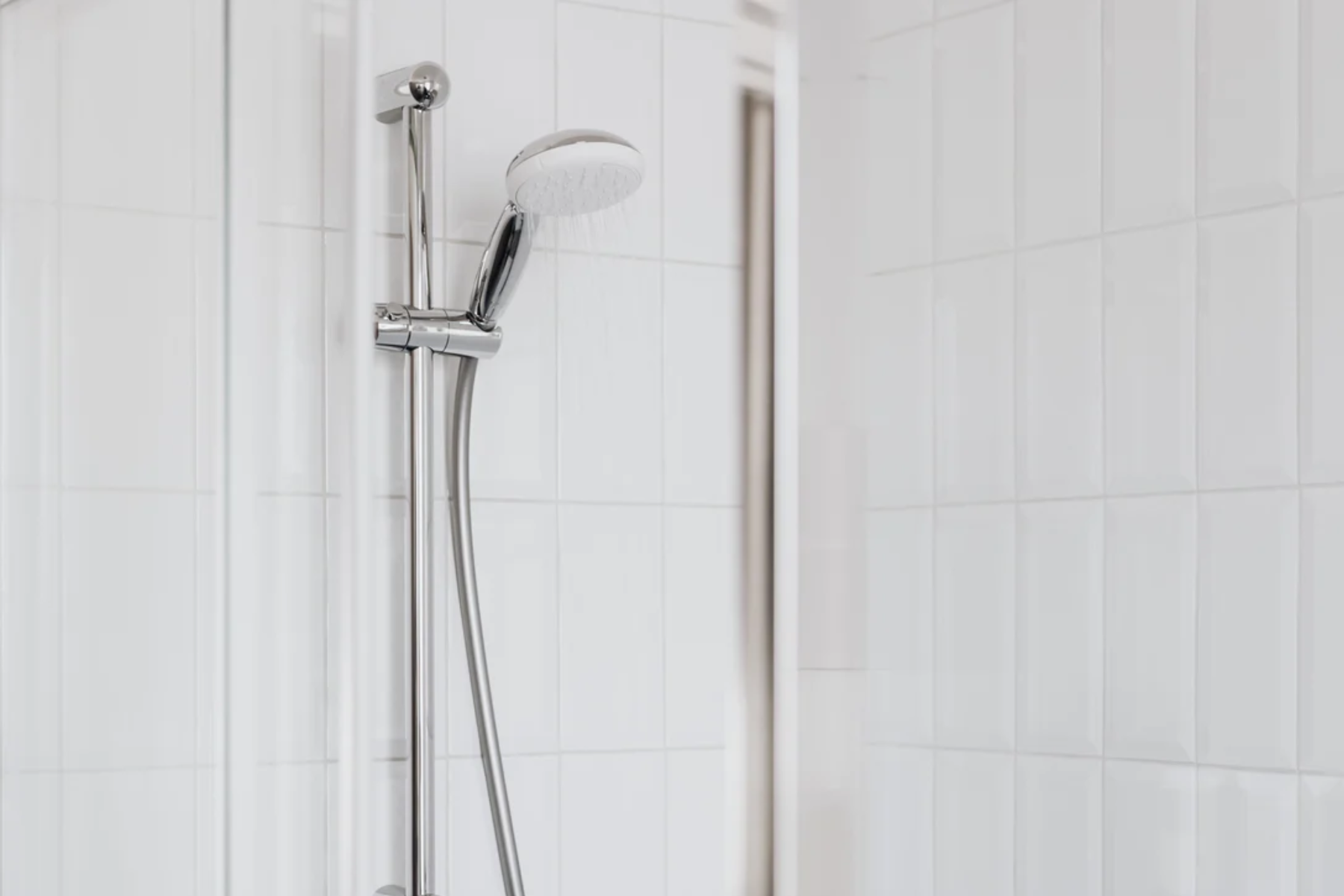 Thermostatic Shower Mounted On White Tiled Background