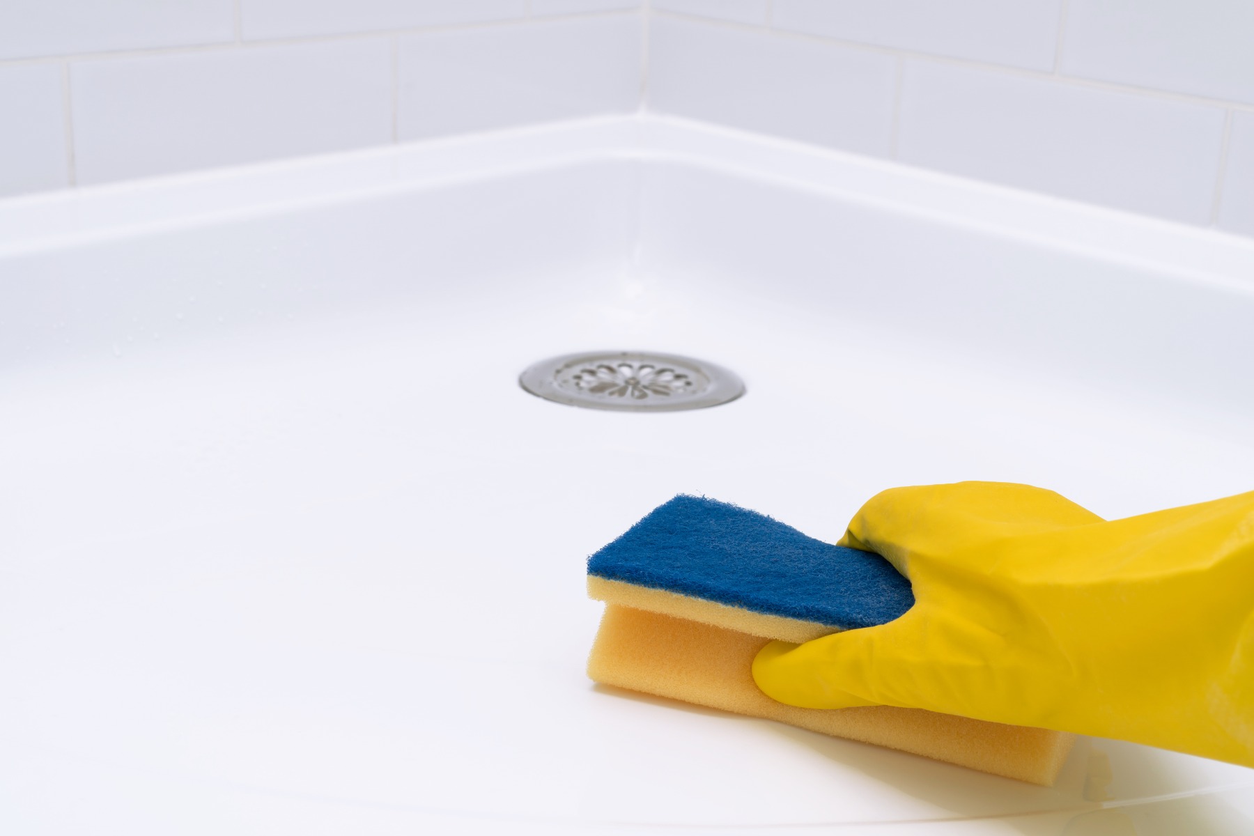 Shower Tray Getting Cleaned By Homeowner In Yellow Gloves