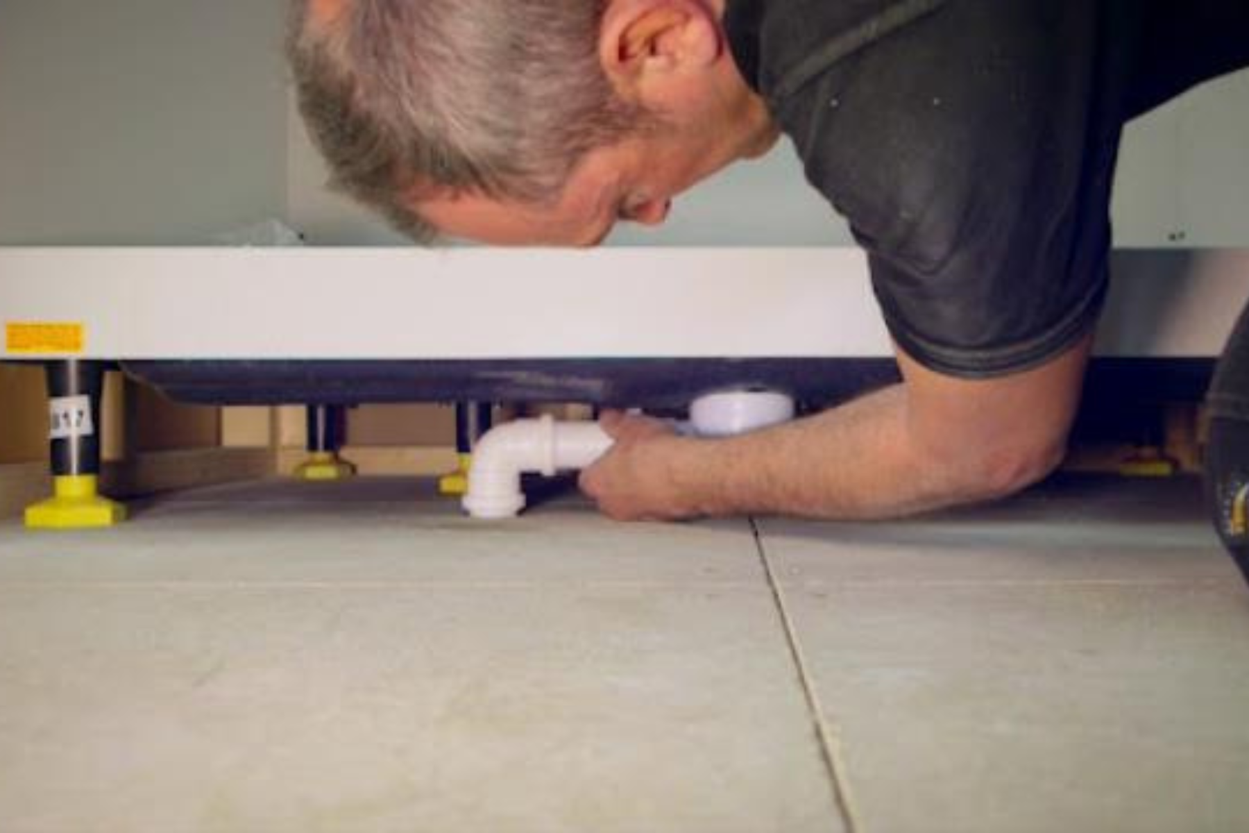 Shower Tray With Pipe Getting Fitted By Plumber